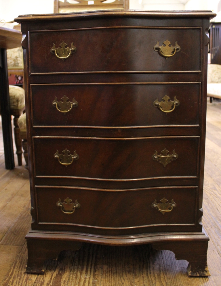 A Regency style mahogany and cross banded serpentine fronted bedside chest with shaped top, four