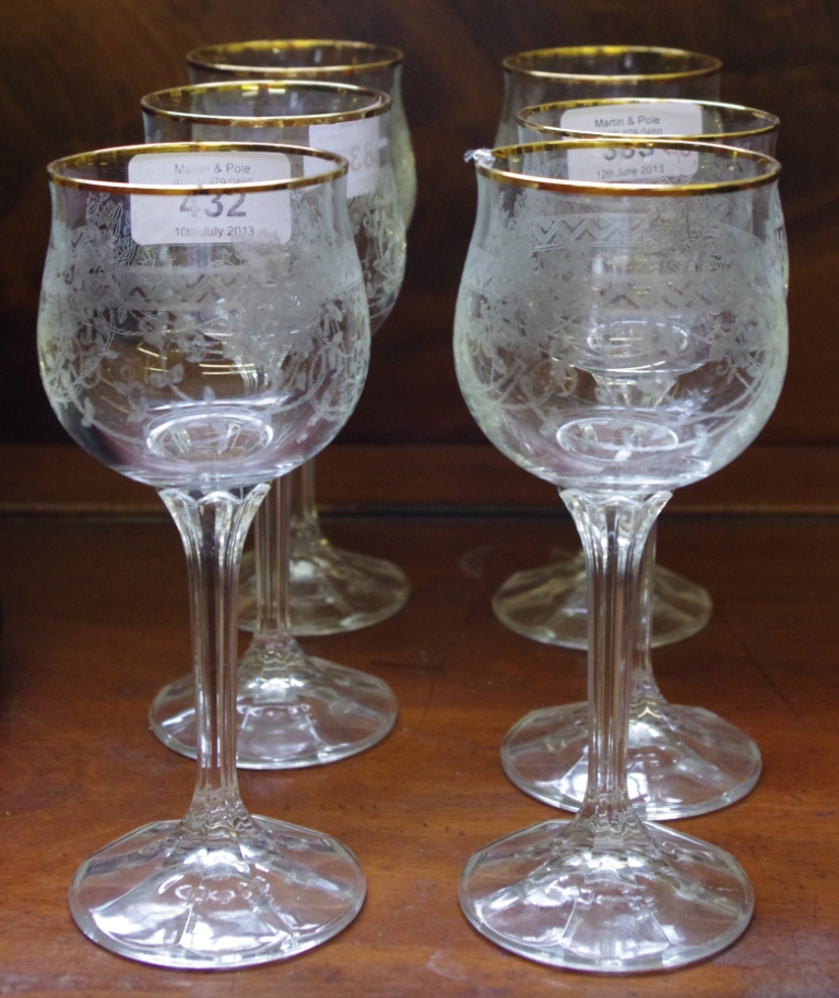 A set of six etched red wine glasses with gold rim and fluted stem