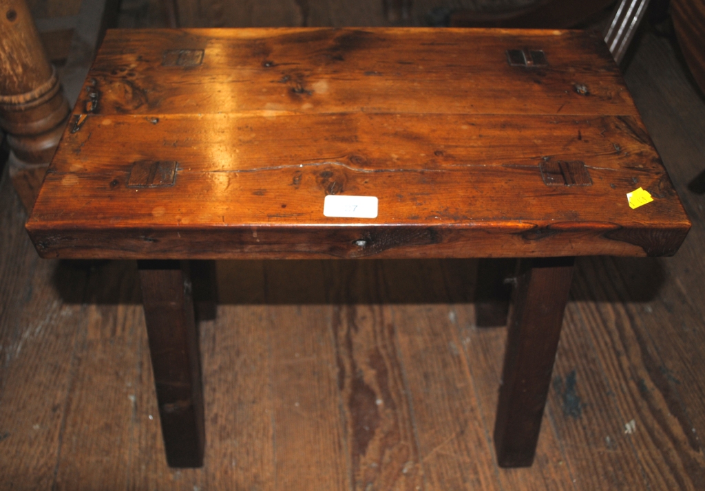 A 19th century hard wood oblong shaped stool, raised on four tapering legs