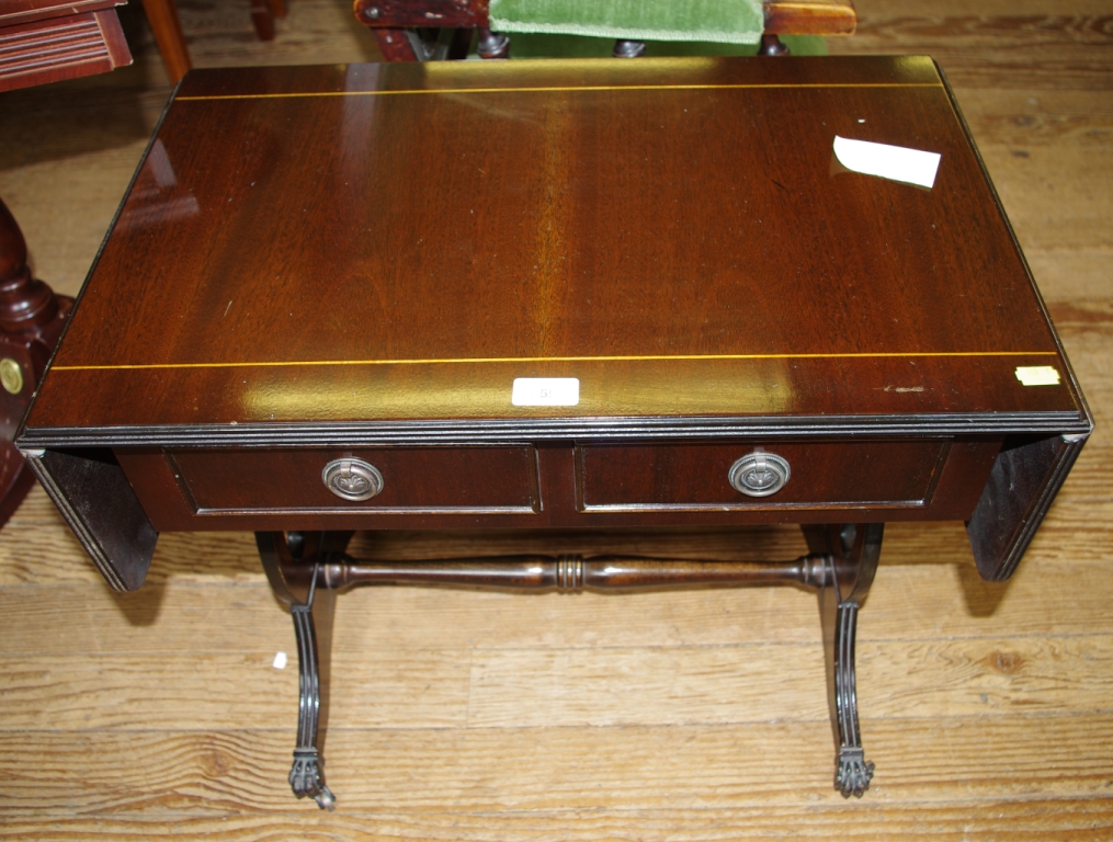 A Georgian style mahogany low sized sofa table with inlay, two drawers under with circular metal