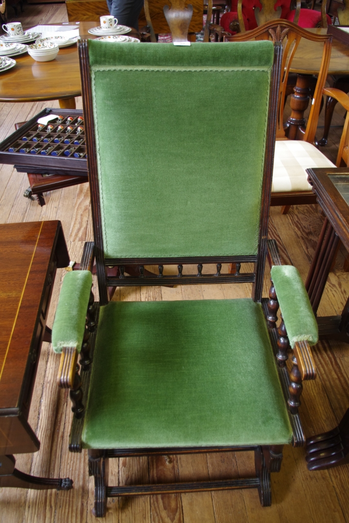 A Victorian mahogany rocking chair with upholstered seat and back with fluted supports and arms,