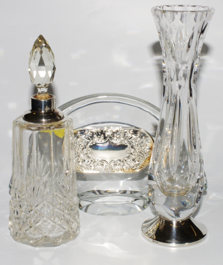 A silver topped glass scent bottle, together with a glass vase with silver base and a napkin