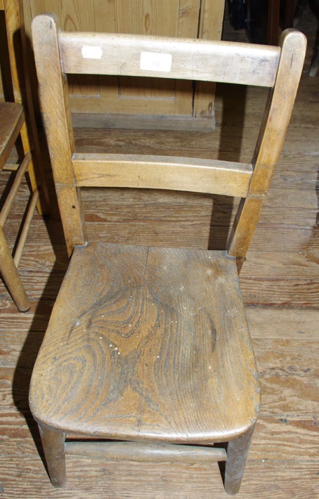 A 19th century child`s chair with an elm seat raised on turned legs and stretcher support