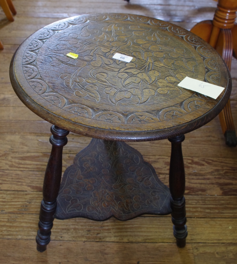 An Arts and Crafts oak circular or occasional table with profuse floral and foliate decoration to