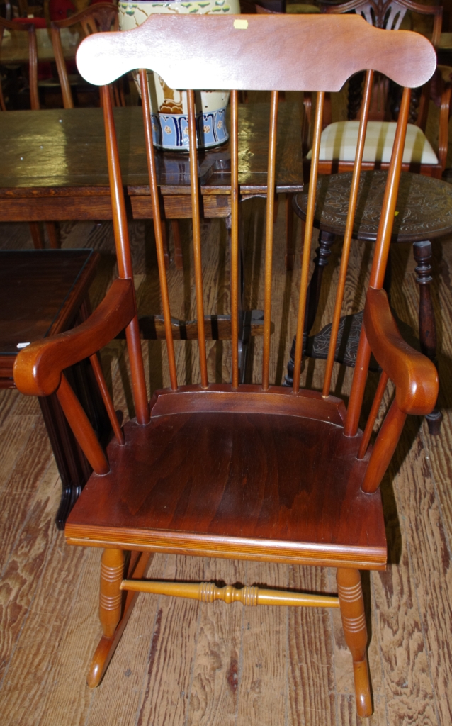 A mid 20th century hardwood Windsor style rocking chair with spindle back, shaped arms raised on