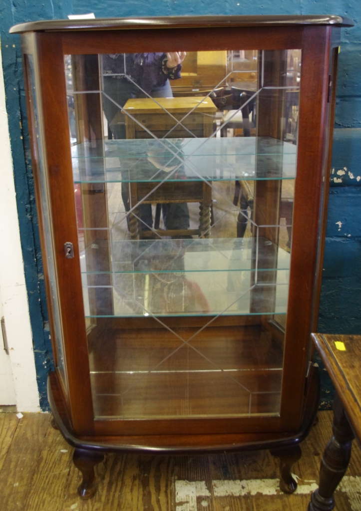 An early 20th century mahogany display cabinet with shaped top, astragal doors, shelved interior