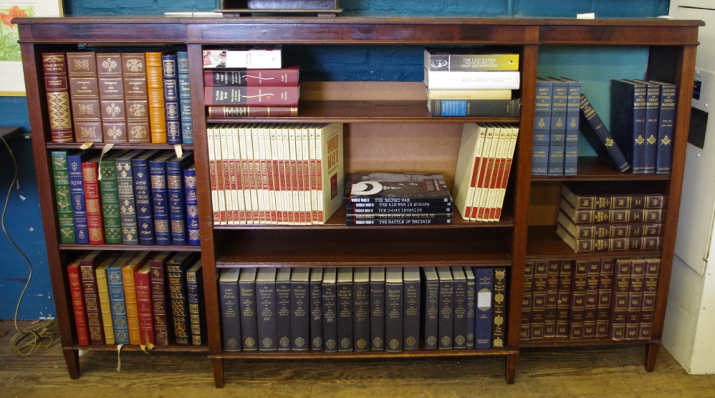 An early 20th century break front free standing mahogany bookcase with shaped top, plain frieze with