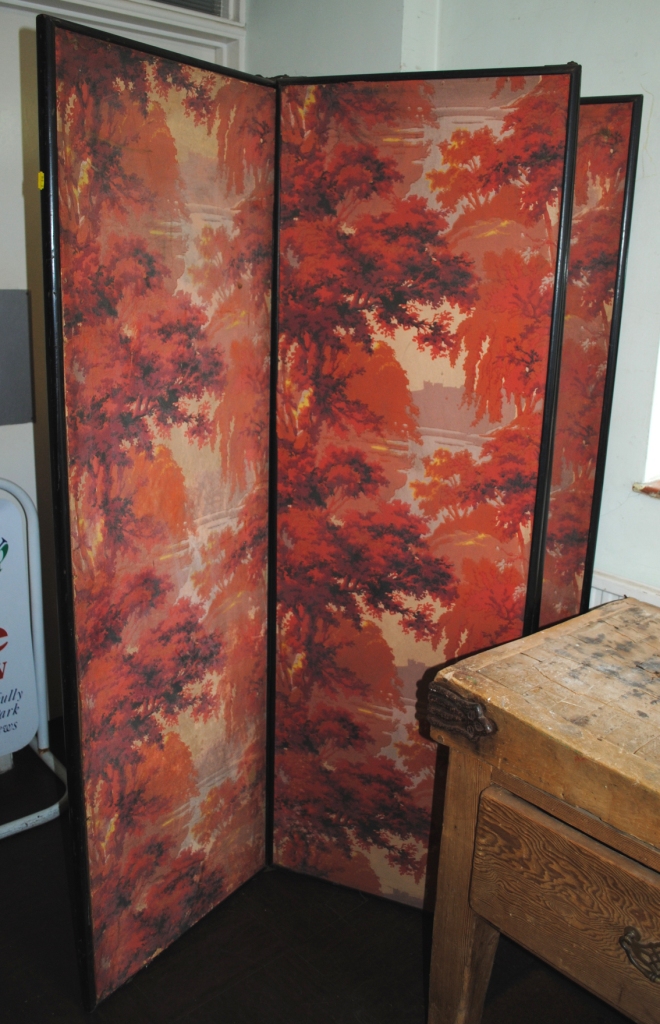 An early 20th century Oriental style four panel dressing screen with floral and foliate decoration
