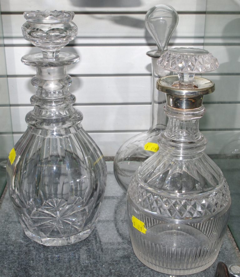 Two circular cut glass decanters with stoppers, together with an etched glass decanter