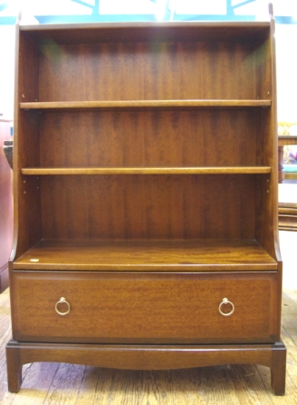 A mid 20th century mahogany freestanding cascading bookcase with three shelves, one drawer under