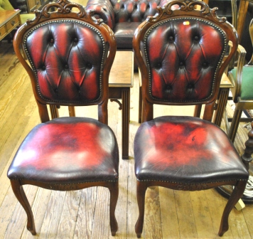 A pair of Victorian style red leather upholstered drawing room chairs with `C` scroll decoration