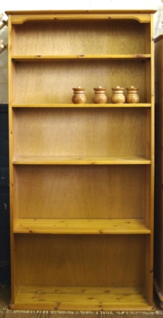 A modern open pine bookcase with adjustable shelves on shaped base measuring 180x90cm