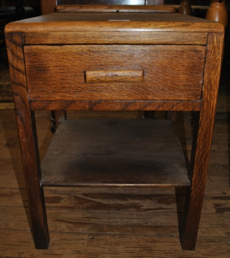 An early 20th century oak bedside table or locker with shaped top, one drawer under, shelf beneath