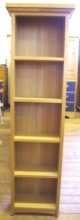 A tall narrow beech bookcase containing five shelves and measuring 116x33cm