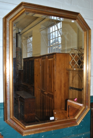 An octagonal shaped bevelled mirror with gilded frame