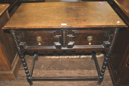 A 19th Century continental oak hall table with shaped top, two drawers on bobbin turned legs and