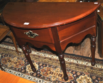 A mahogany demi lune table with single central drawer supports on four turned legs