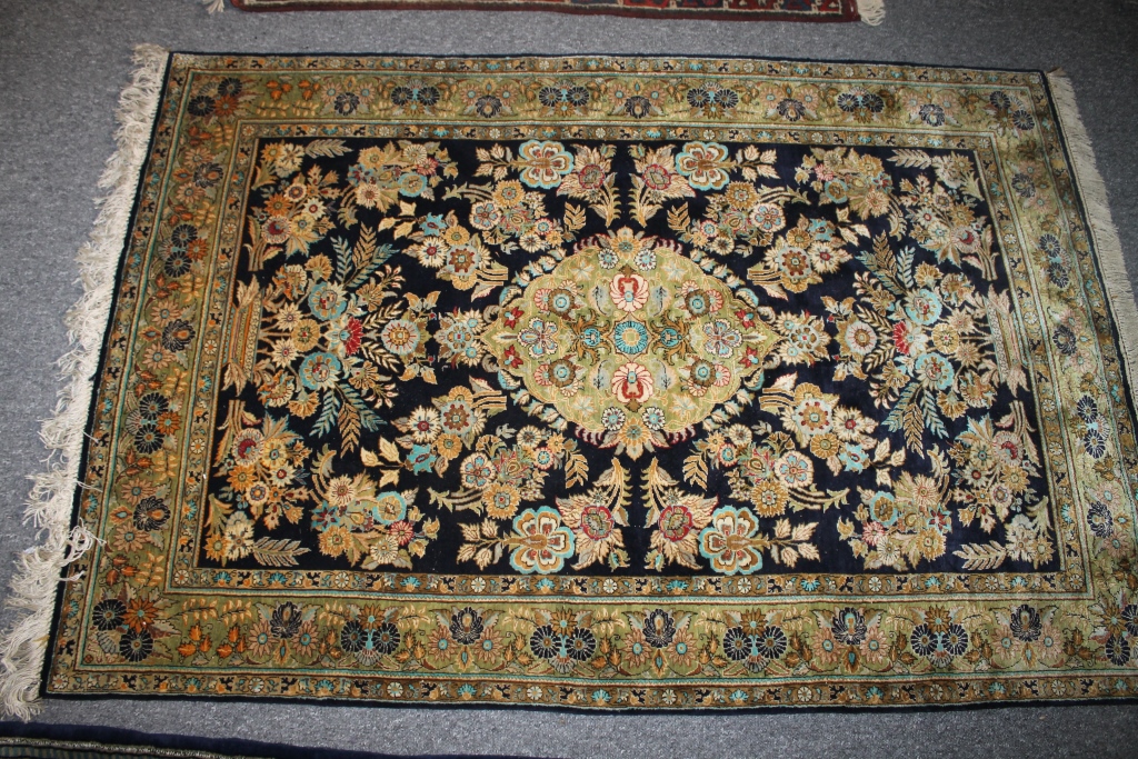 A KASHAN TYPE SILK RUG with central foliate medallion on a blue ground, within a multiple border