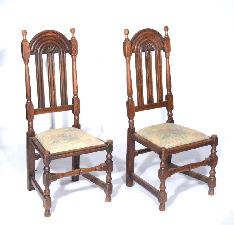 A PAIR OF LIBERTY AND CO OF LONDON OAK HIGH BACK HALL CHAIRS in the 17th Century style with drop-