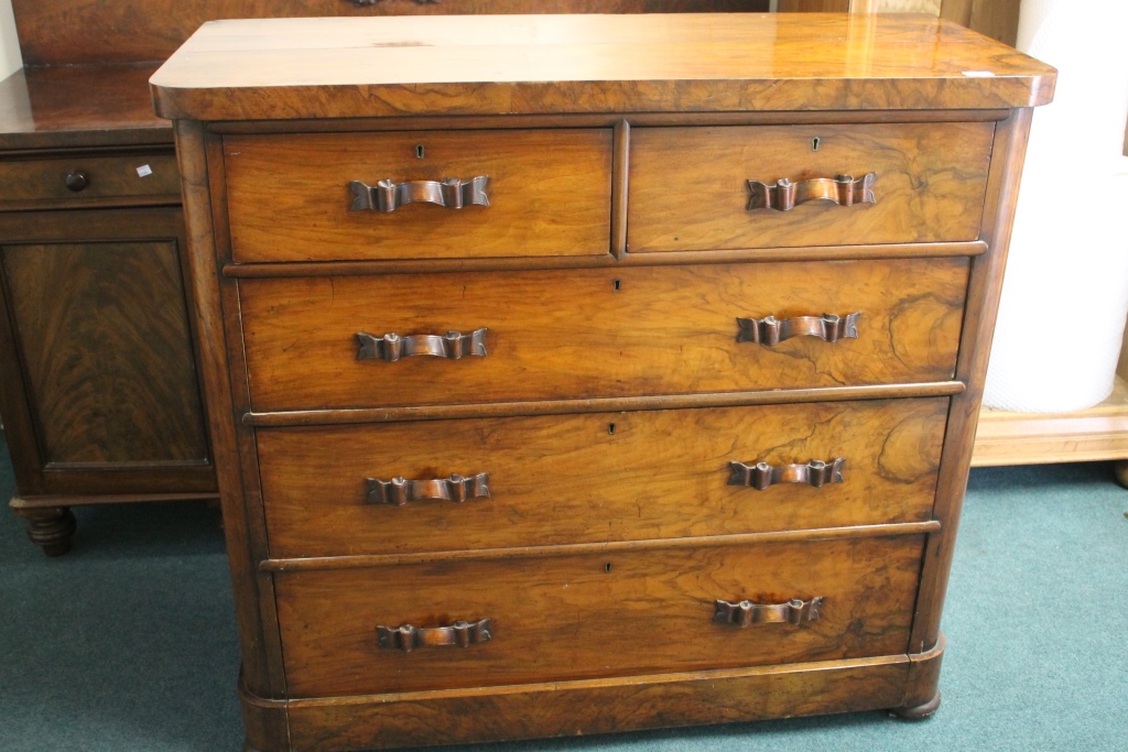 A VICTORIAN WALNUT STRAIGHT FRONT CHEST of two short and three long drawers with carved handles,