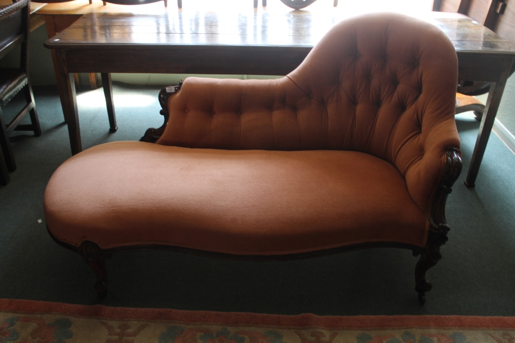 A VICTORIAN ROSEWOOD CHAISE LONGUE with button upholstery and serpentine front on cabriole supports