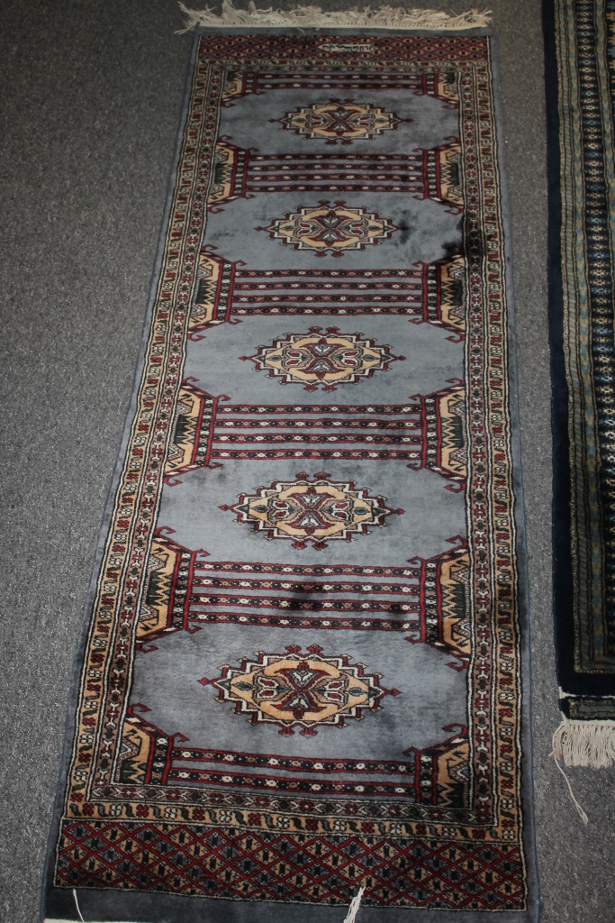 AN AFGHAN PALE BLUE GROUND RUG with five medallions and within a geometric border, 66cmx 176cm