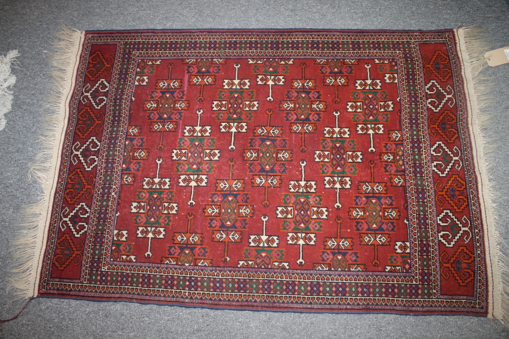 A BOKHARA TYPE RED GROUND RUG with elephant`s foot designs, 122cm x 84cm and another similar smaller