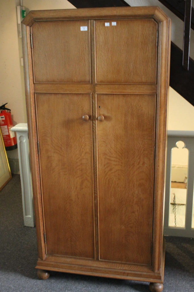 A HEAL & SON LIMED OAK WARDROBE with plain interior, a pair of panelled doors, inset with ivorine