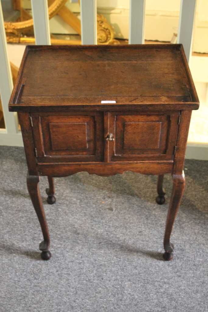 AN ANTIQUE OAK TRAY TOP BEDSIDE TABLE with cupboard doors on cabriole legs, 50cm