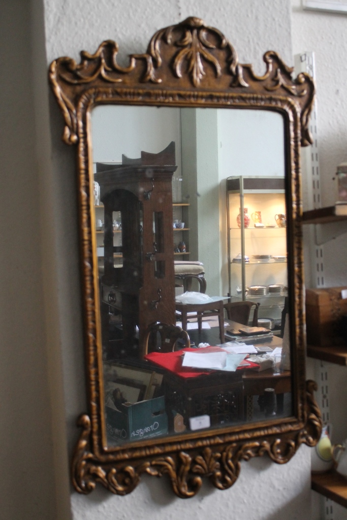 A GILTWOOD WALL MIRROR in the George III style, circa 1920, having a scroll frame, 93cm x 57cm