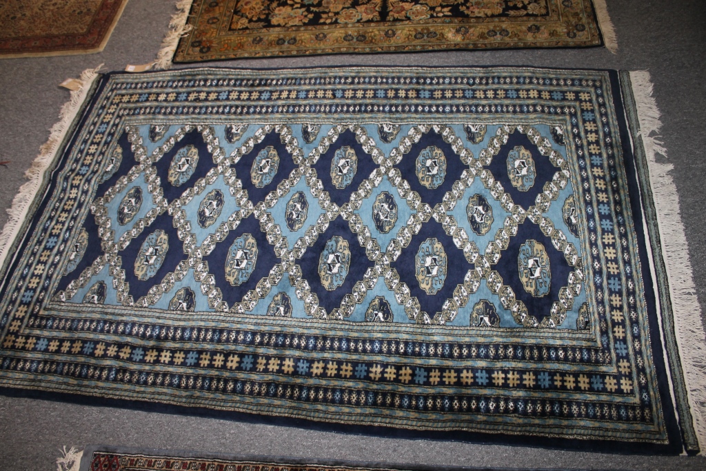 AN AFGHAN BLUE GROUND RUG with two rows of medallions within a multiple border, 200cm x 130cm