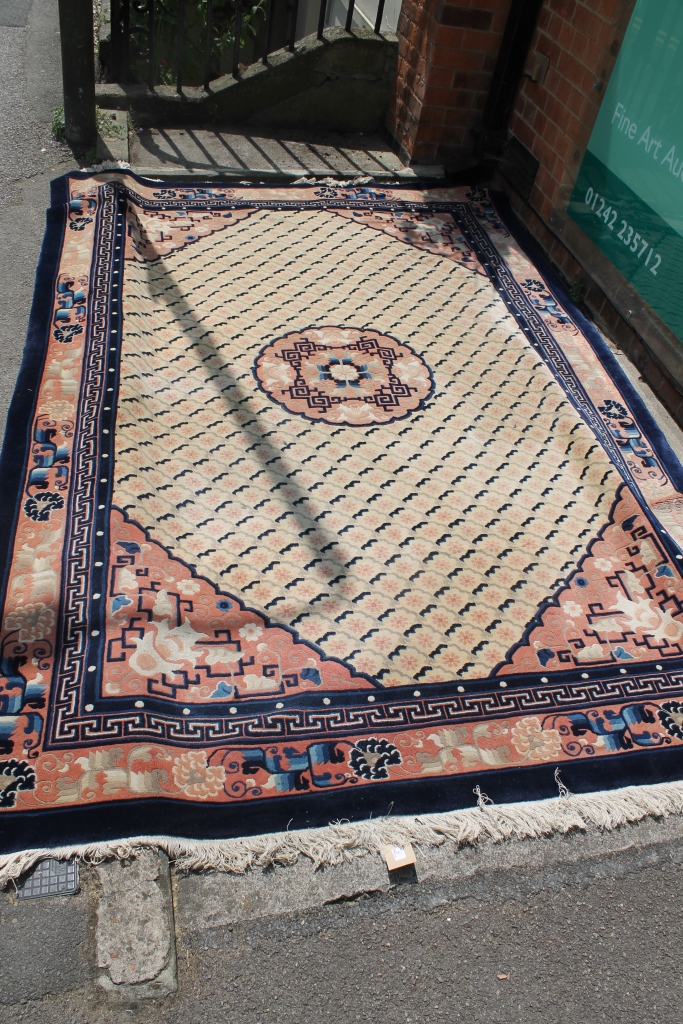 A CHINESE SMALL CARPET having a central circular medallion within a traditional border with