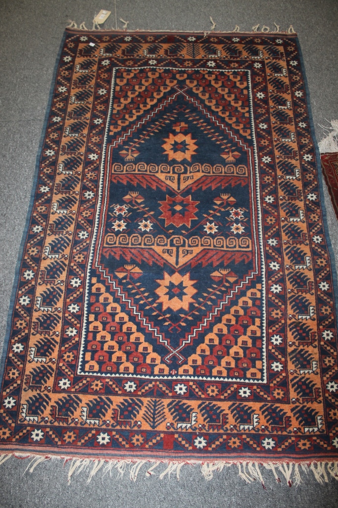 A PAKISTAN BLUE GROUND RUG with allover geometric decoration, 183cm x 106cm