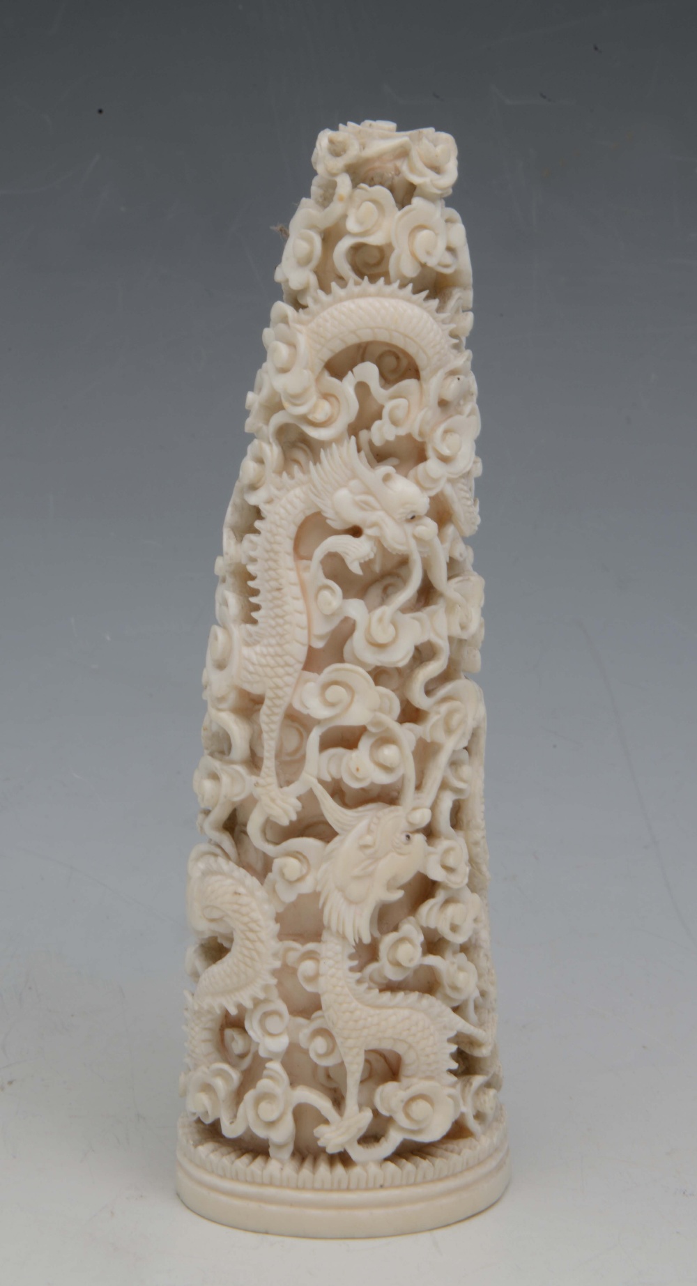 A CHINESE CANTON PIERCED AND CARVED IVORY TUSK ORNAMENT, decorated dragons and scrolling clouds,