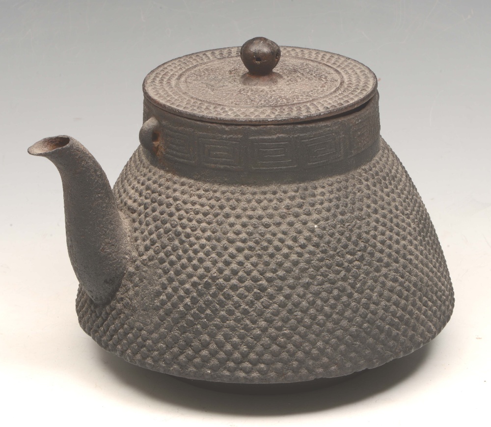 A JAPANESE IRON TEAPOT and cover with two side lugs for the handle, and with a Greek Key type