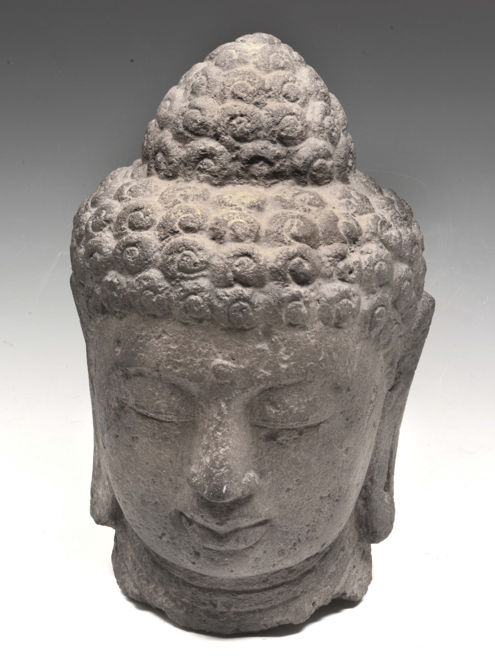 A LARGE STONE HEAD OF JINA OR BUDDHA, possibly Indonesian, well carved with face in a pleasant