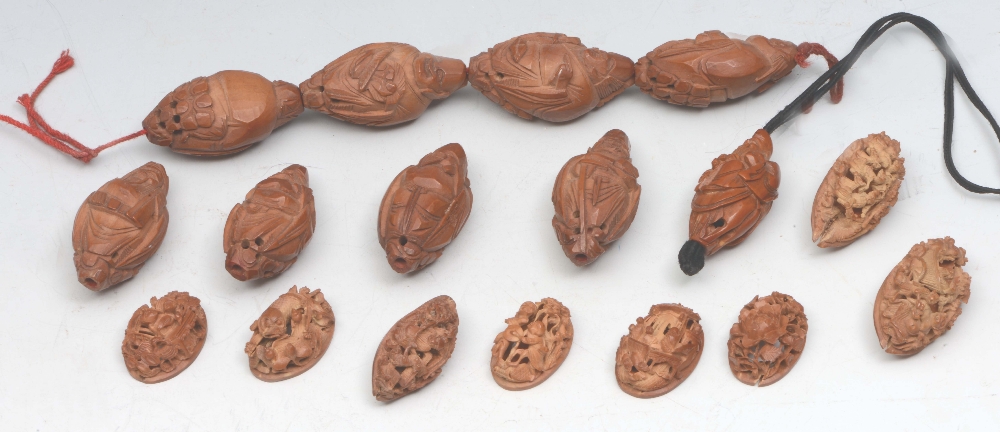 A COLLECTION OF CHINESE CARVED COQUILLA NUT KERNEL SEEDS, carved as figures, 19th Century, and