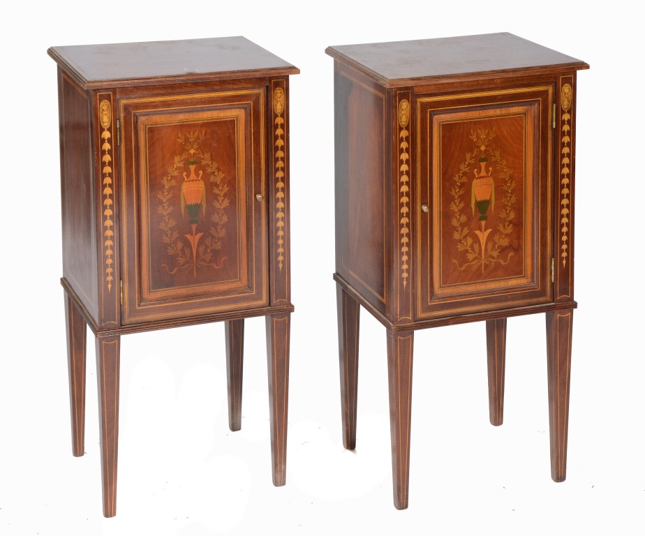 A PAIR OF EDWARDIAN MAHOGANY POT CUPBOARDS enclosed by single panel doors on tapering supports,