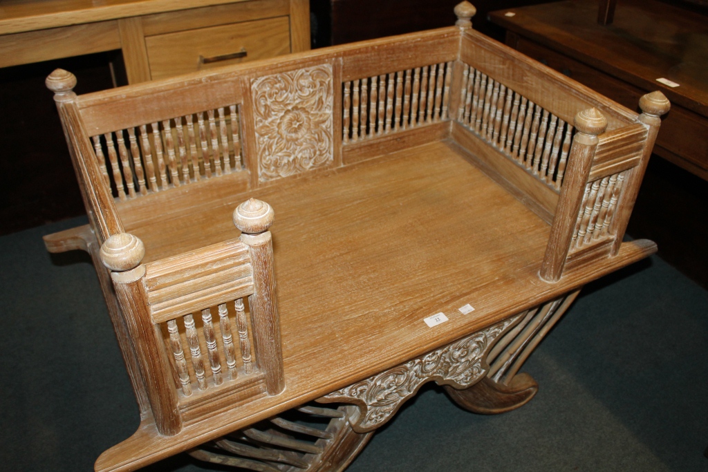 AN INDIAN LIMED OAK HOWDAH with carved decoration and turned spindle supports