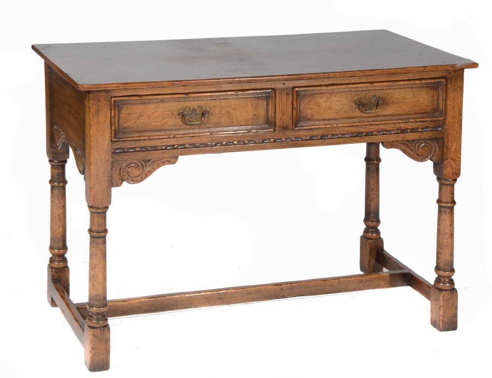 AN OAK REPRODUCTION JACOBEAN STYLE SIDE TABLE fitted two drawers with carved decoration, 42"