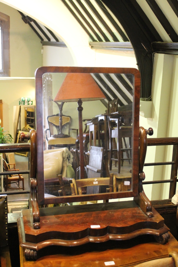 A VICTORIAN MAHOGANY SWING DRESSING TABLE MIRROR on scroll supports