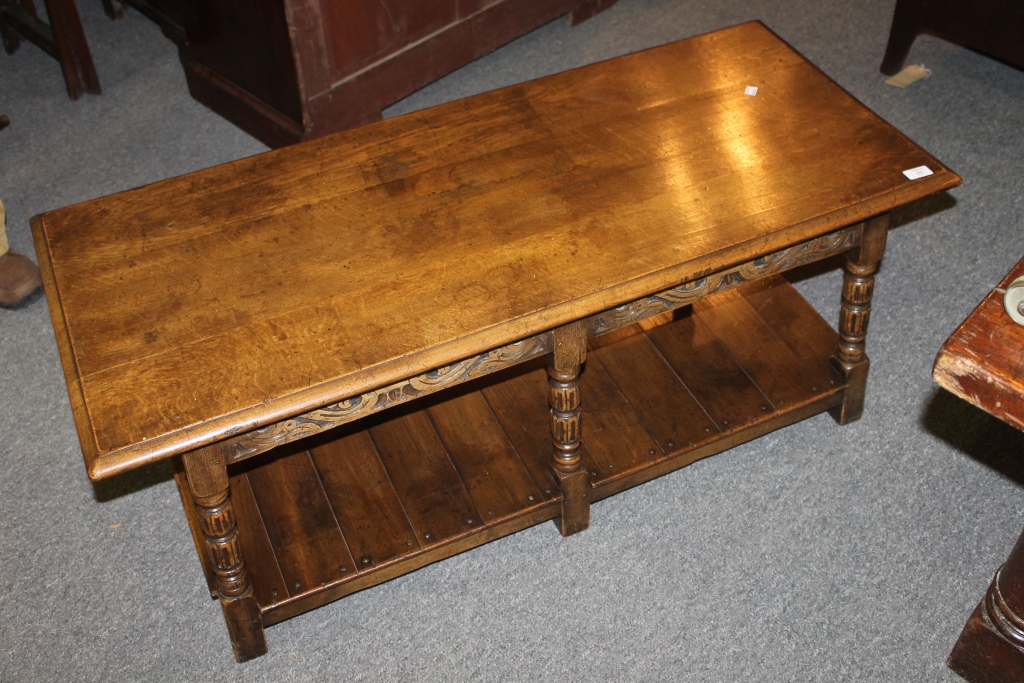 A CARVED OAK COFFEE TABLE with fluted supports, 48"