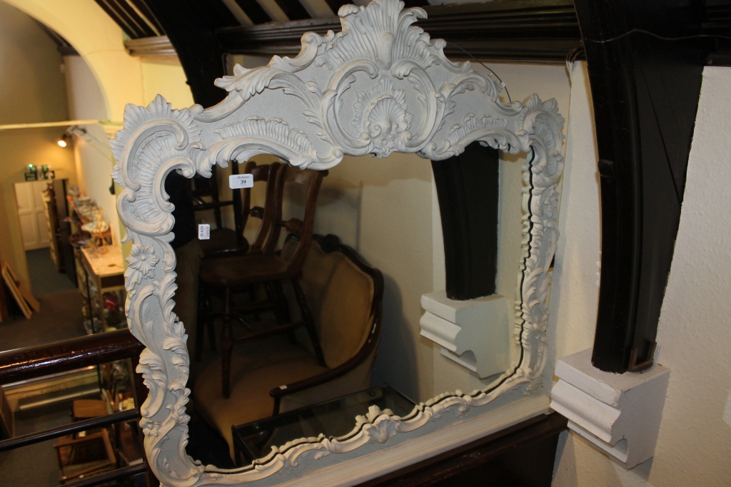 A REPRODUCTION GILT FOLIATE SCROLL SMALL OVERMANTEL MIRROR, now white painted, 36" across