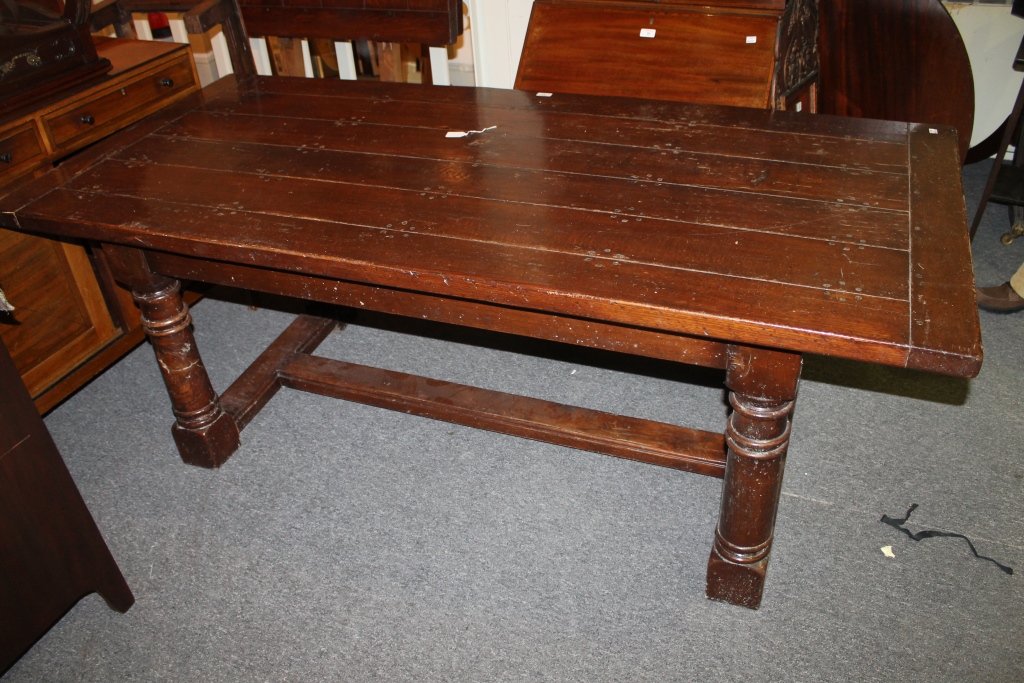 AN OAK REFECTORY TABLE with turned supports, the rectangular top with cleated ends and plank top,