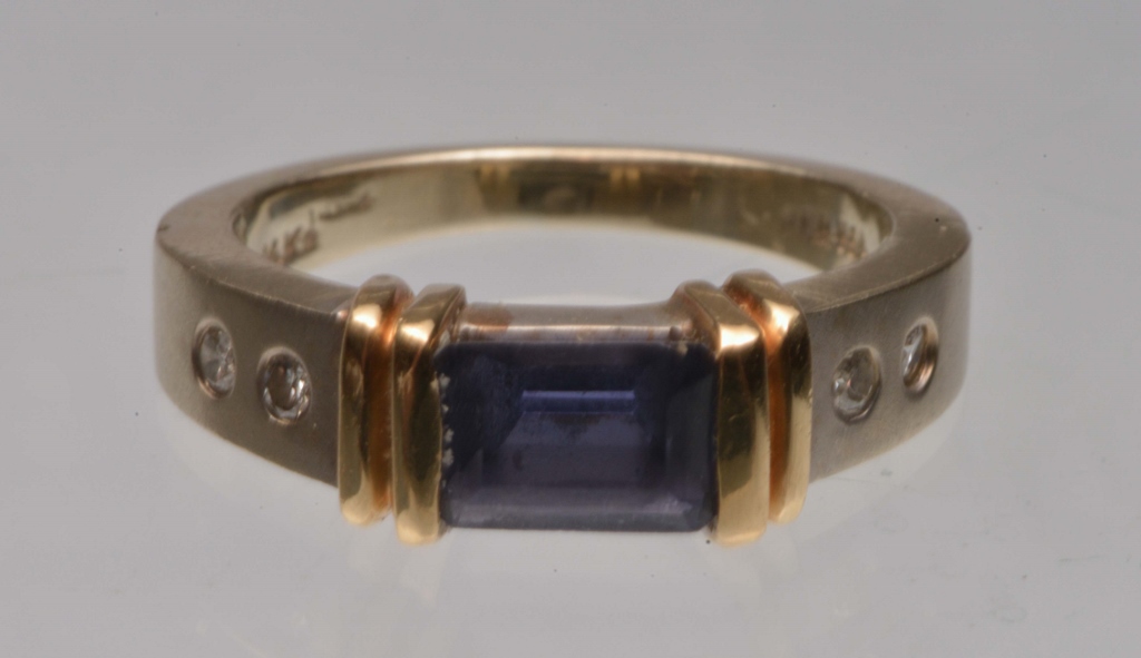 A CONTEMPORARY SAPPHIRE AND DIAMOND SET DRESS RING, trap cut sapphire mounted in a part rub over