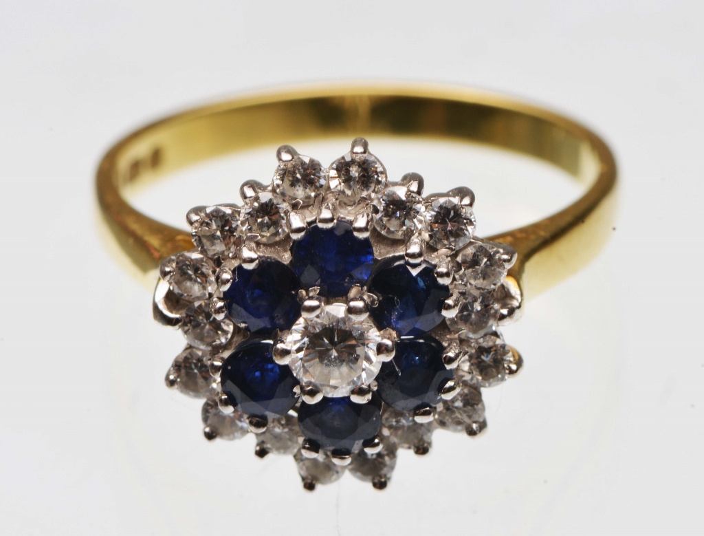 A SAPPHIRE AND DIAMOND SET DRESS RING in the form of a cluster, central brilliant cut diamond