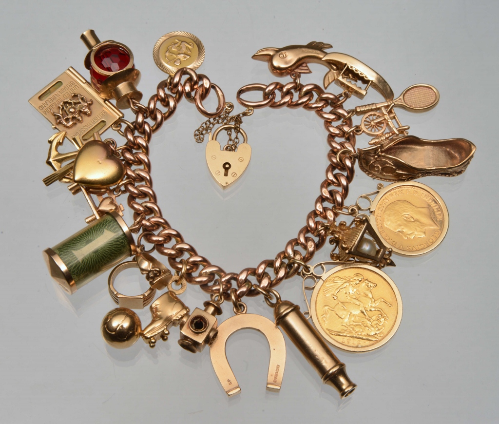 A 9CT GOLD CURB LINK BRACELET with eighteen attached charms, one set with a gold sovereign and one