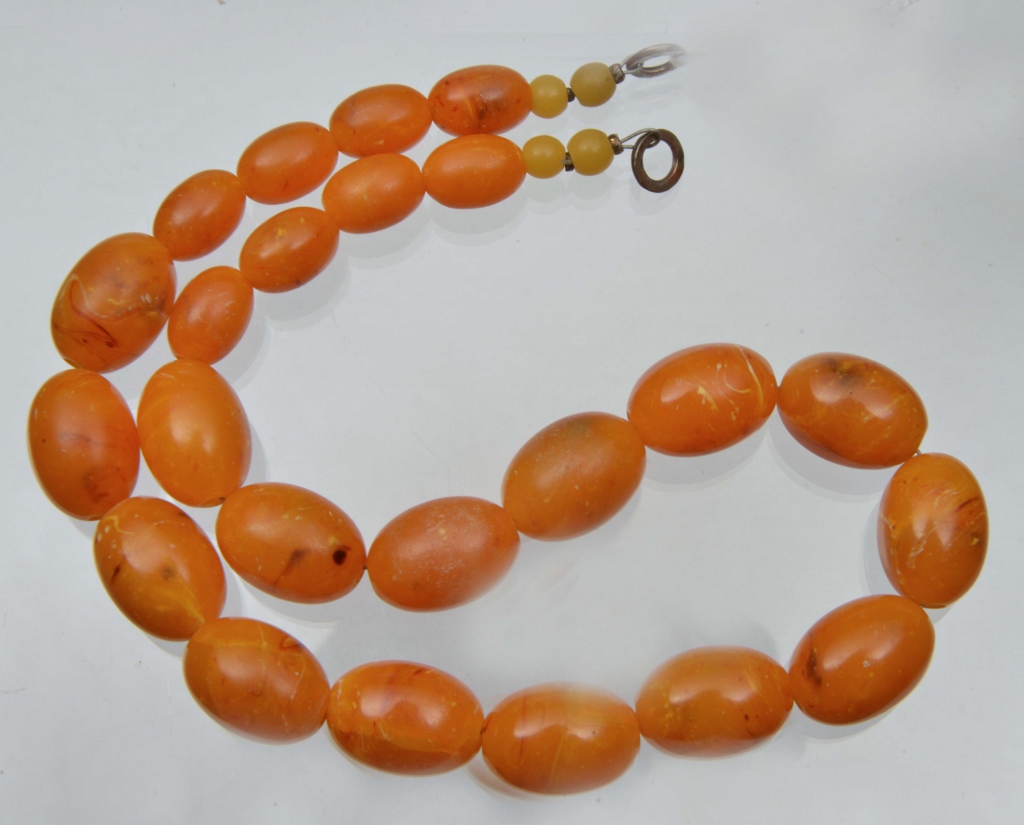 A RECONSTITUTED OVAL AMBER BEAD NECKLACE, 17" long, 14mm beads down to 10mm, 43 grams