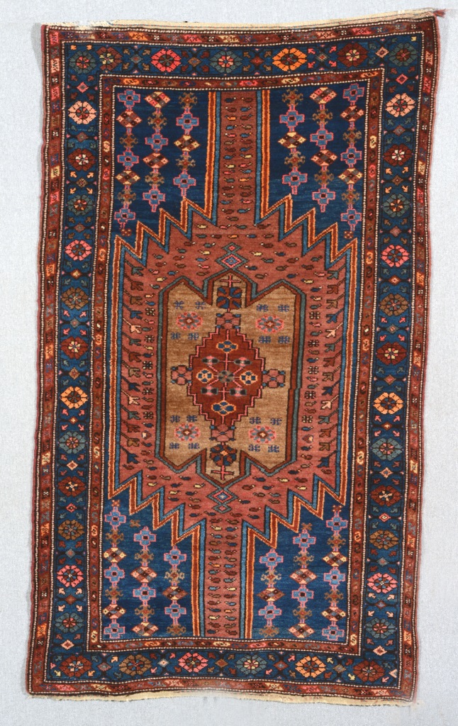 A HAMADAN RUG with a central multiple polychrome medallion within a blue ground rosette border, 1.