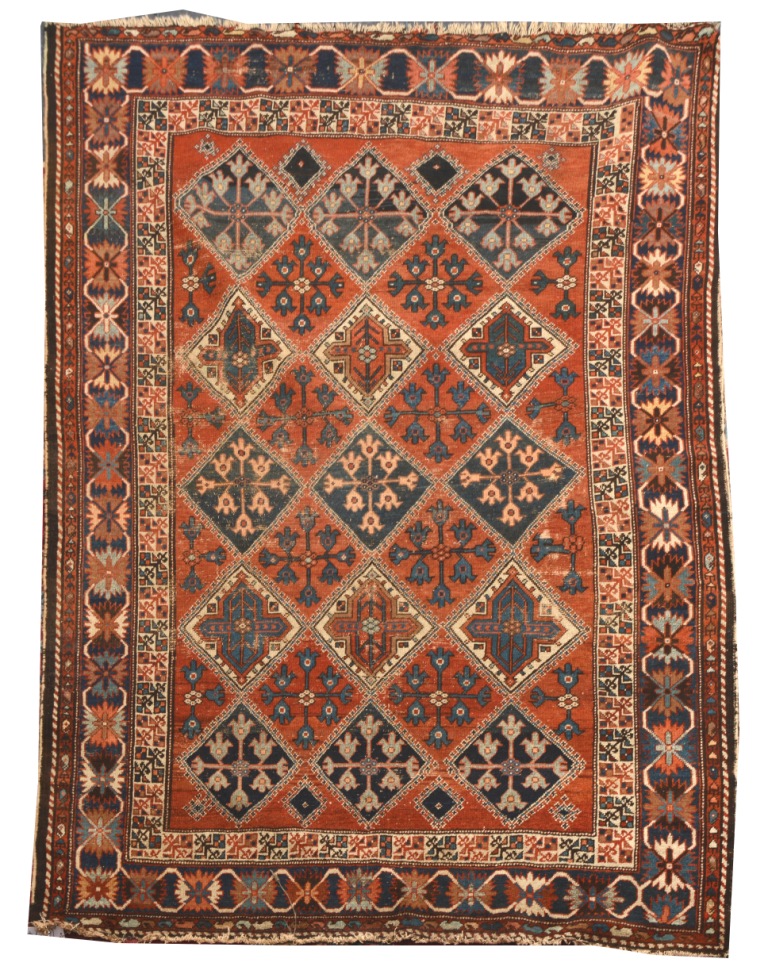 A BAKHTIARI RUST GROUND RUG decorated three rows of five stylised diamonds within a polychrome